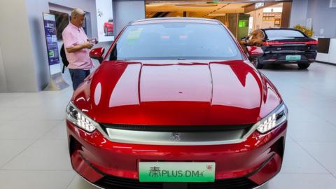 A man looks at an electric car in a BYD store in Shanghai, China.
