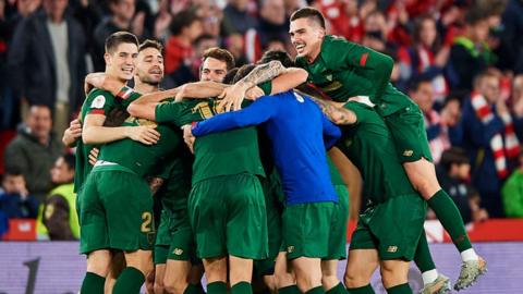 Athletic Bilbao players in a celebratory group huddle