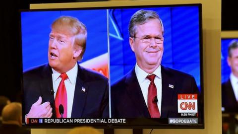 Republican U.S. presidential candidates businessman Donald Trump (L) and former Governor Jeb Bush (R) are seen debating on video monitors in the debate press room during the Republican presidential debate in Las Vegas, Nevada December 15, 2015