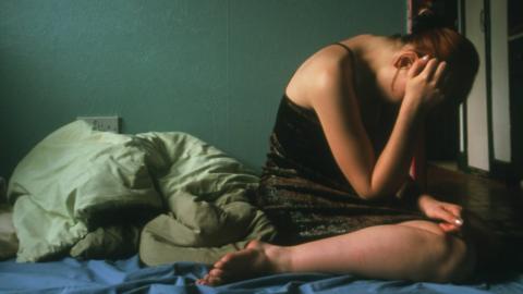 Distressed woman on bed - file pic
