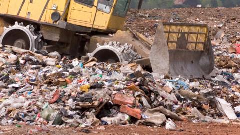 Picture of generic landfill site with yellow bulldozer