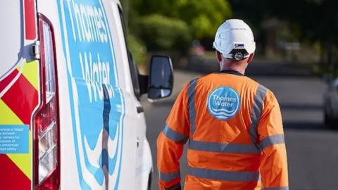 A worker walking next to a van