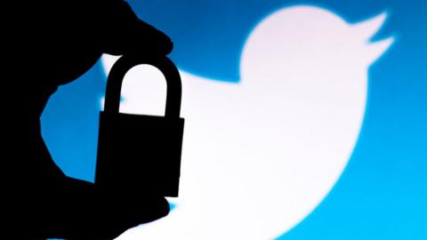 The silhouette of a padlock in front of the Twitter logo
