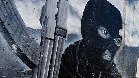 A mural of a man wearing a balaclava and holding a gun