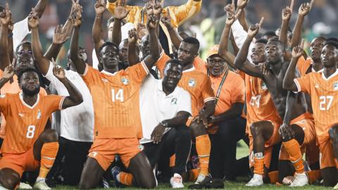 Ivory Coast players and coaching staff celebrate beating Senegal at the 2023 Africa Cup of Nations