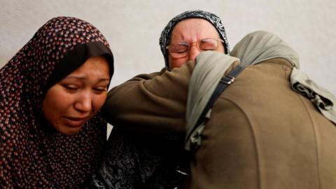 Mourners react following the death of Palestinians in an Israeli strike on Thursday