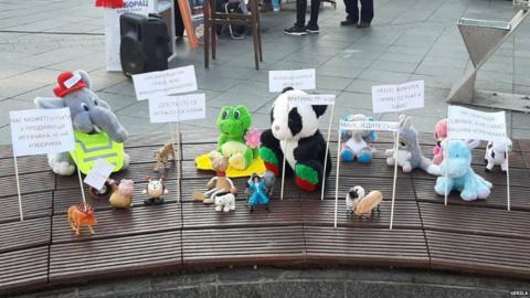 Soft toys arranged on a bench with protest slogans in Banja Luka