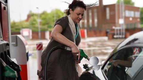 Woman fills car with fuel