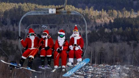 Skiers dressed as Santa Claus ride the lifts to participate in the charity Santa Sunday at Sunday River ski resort in Bethel, Maine, USA. 5 December 2021.