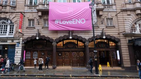 Banner hung at the English National Opera in London, in response to funding cuts if it doesn't move to Manchester.