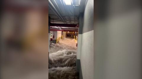 Water rushes into parking garage