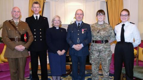 Photo from the ceremony: (Left to right), Lieutenant Grace, LT Coase, Reverend Erica Scott (chaplain King William’s College), Wing Commander Thrussell, RSM (Regimental Sergeant Major) Walters and PO (Petty Officer) Channel.