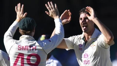 Australia's Steve Smith (left) and Pat Cummins (right) celebrate after Cummins takes the key wicket of Rohit Sharma during day four of the third Test against India