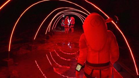 People in "space suits" walking down a tunnel