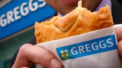 Man eating Greggs pasty