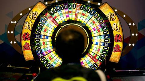 A man tries his luck at a wheel of fortune machine