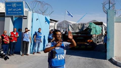 UN worker assists aid trucks arriving into a U stirage facility as the war between Israel and Hamas continues. Picture taken on 21 October 2023.