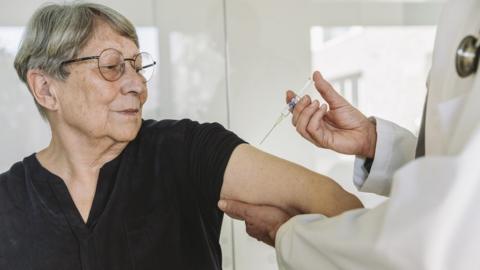 Stock photo of a woman being injected by a doctor