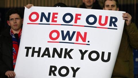 Crystal Palace fans hold up posters thanking Roy Hodgson during their Premier League game at Everton Monday