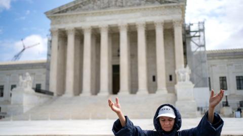 A demonstrator prays outside tha US Supreme Court up in Washington, DC, US, on Thursday, April 25, 2024