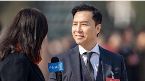 Actor Donnie Yen speaks to a reporter