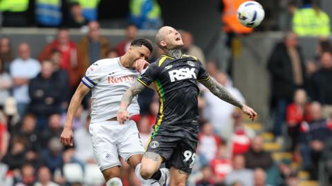 Ben Cabango and Lyndon Dykes compete for a header 