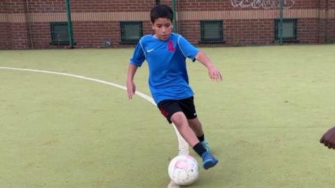 A child kicking a football