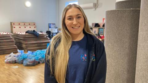 lady with blonde hair smiling with blue tshirt
