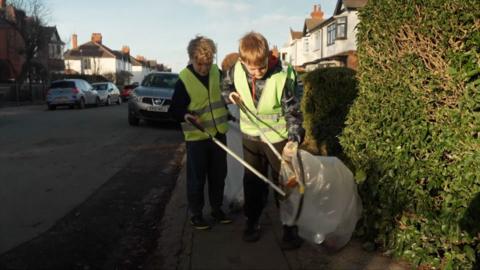 Children litter picking where they live