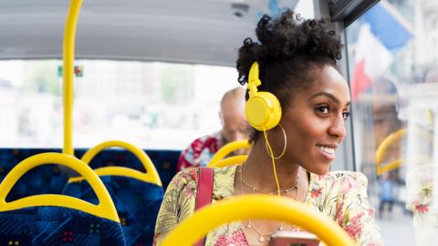 Portrait of woman relaxing on a bus wearing headphones