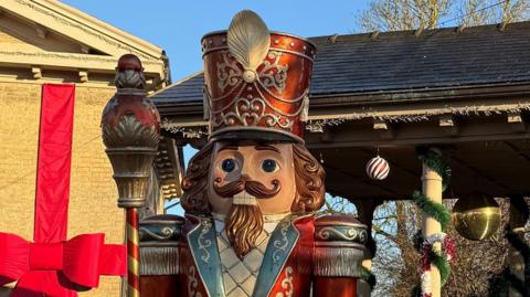 A model of a Christmas nutcracker soldier standing in front of a well
