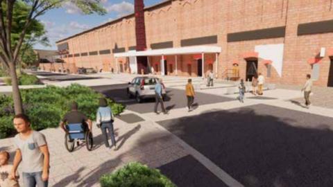 A CGI of how the piazza space, known as George Court will look. A number of people are walking across the road. There are wide footpaths on either side of the road and trees and greenery to the left. A white awning has been built over the entrance to the red brick building to the right.