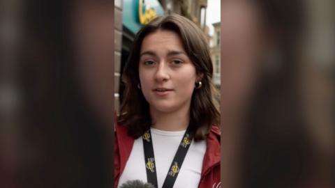 A young woman in white tshirt and red jacket.
