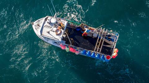 A drone photo of a shipping boat on the sea from above. 