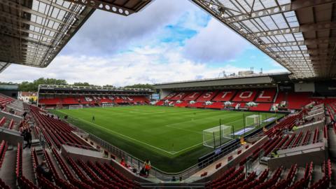 A long-range shot of Ashton Gate stadium, pictured from the upper right hand corner of one of the stands. A football pitch is set up in the middle, and the word 'Bristol' is spelt out in white seats amid blocks of red seats. 