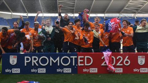 Cardiff City players celebrate promotion at Reading
