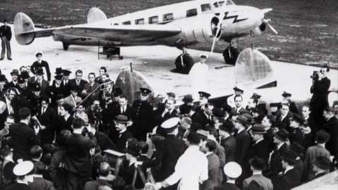 A crowd in front of a plane, waiting for Neville Chamberlain