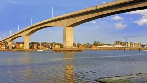 Stock image of the Itchen Bridge. It is grey-concrete and sits high above the water.