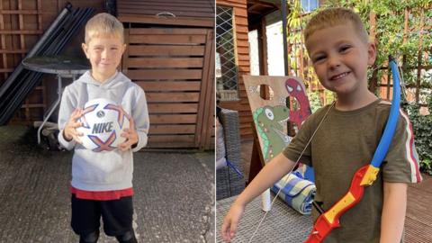 Louie Ellis on the left holding a football. He has short hair and is wearing a grey hooded top and black shorts. Mason Ellis on the right has a toy bow and arrow and has short hair and is wearing a green top.