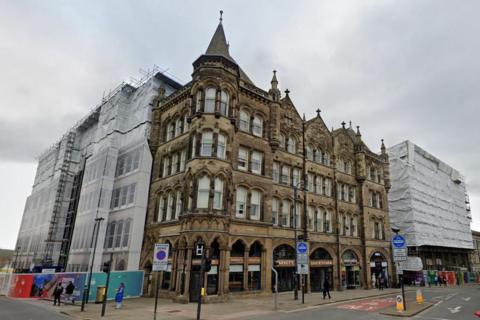 A view of the the Estate Buildings from street level. The building is four-storey's tall and has several spires on its roof.