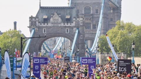Thousands of runners pass across Tower Bridge during the London Marathon 2025