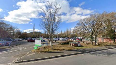 A carpark surrounded by trees. A sign reads Coypool Park and Ride Car Park.