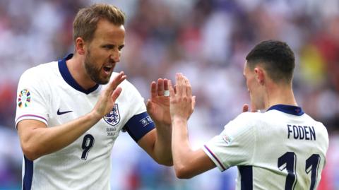 England captain Harry Kane (left) high fives team-mate Phil Foden