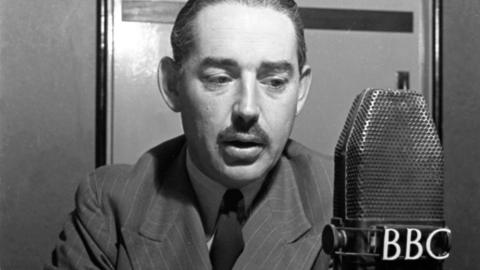 Reporter John Snagge in front of a BBC microphone.