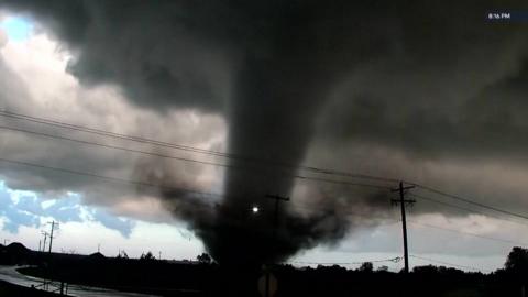 Black tornado visible above treeline