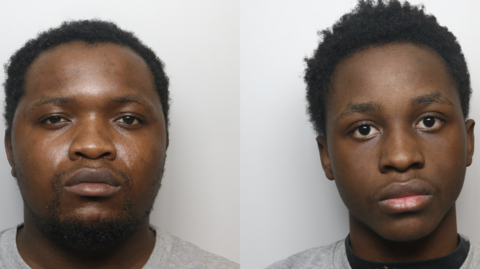 Two men standing side by side, facing the camera against a plain background.