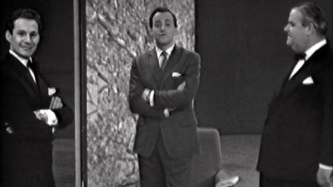 Presenter David Jacobs stands between two men wearing dinner jackets.