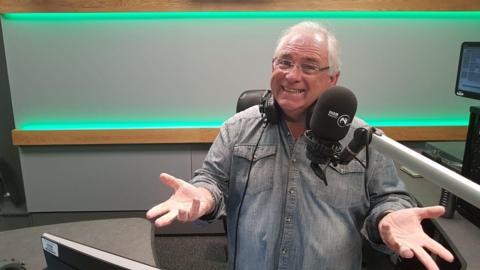 Hugo Duncan sits in a 鶹Լ Studio. He is smiling at the camera.