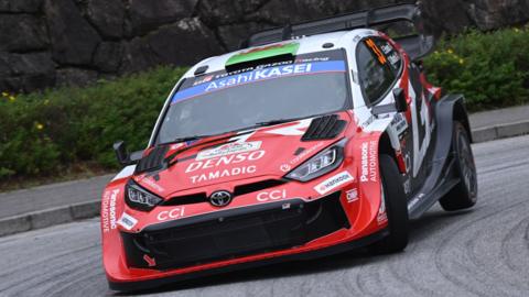 Elfyn Evans' red and white Toyota Yaris Rally1 car corners at Rally Japan