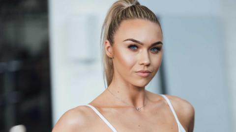 Head and shoulders photo of a young woman with a blonde ponytail